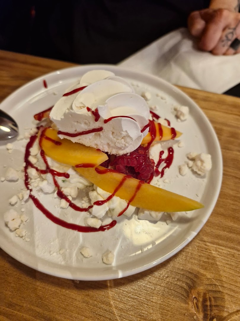 Un dessert de fruits jaunes, framboises et meringue
